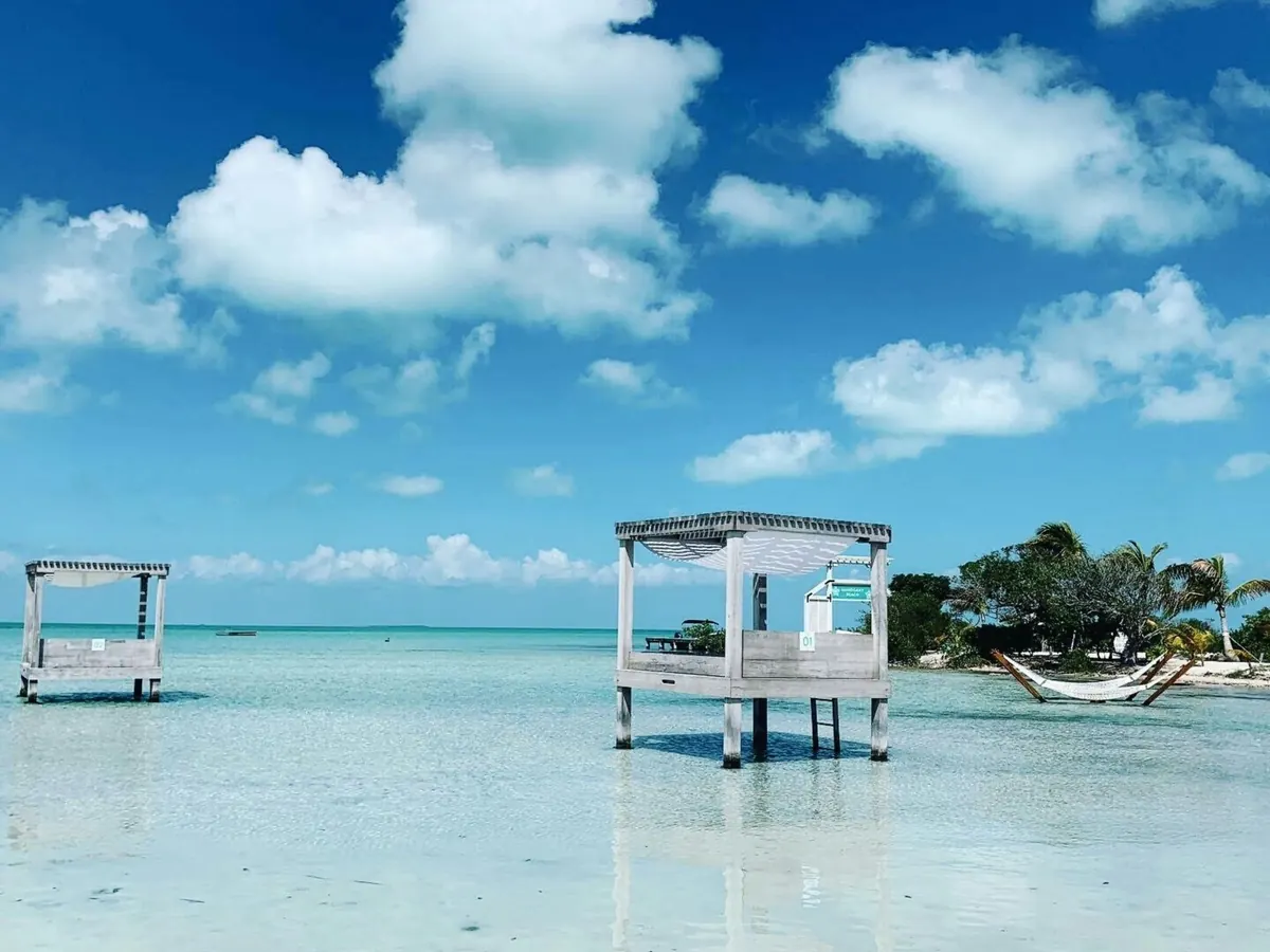 Cabanes sur pilotis au-dessus d'un lagon turquoise, littoral du Belize