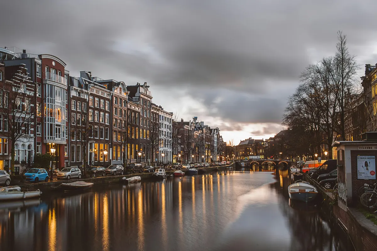 Canal illuminé au crépuscule à Amsterdam, Pays-Bas
